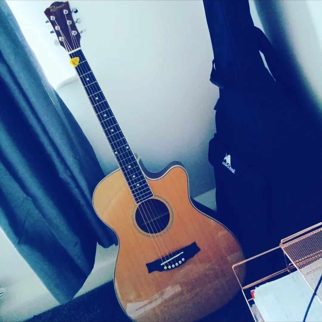  Sara was in excitement about buying her new second-hand Redwood Acoustic guitar and took a photo of the beautiful guitar as is. The guitar is brown with a beautiful woodwork and metal strings.